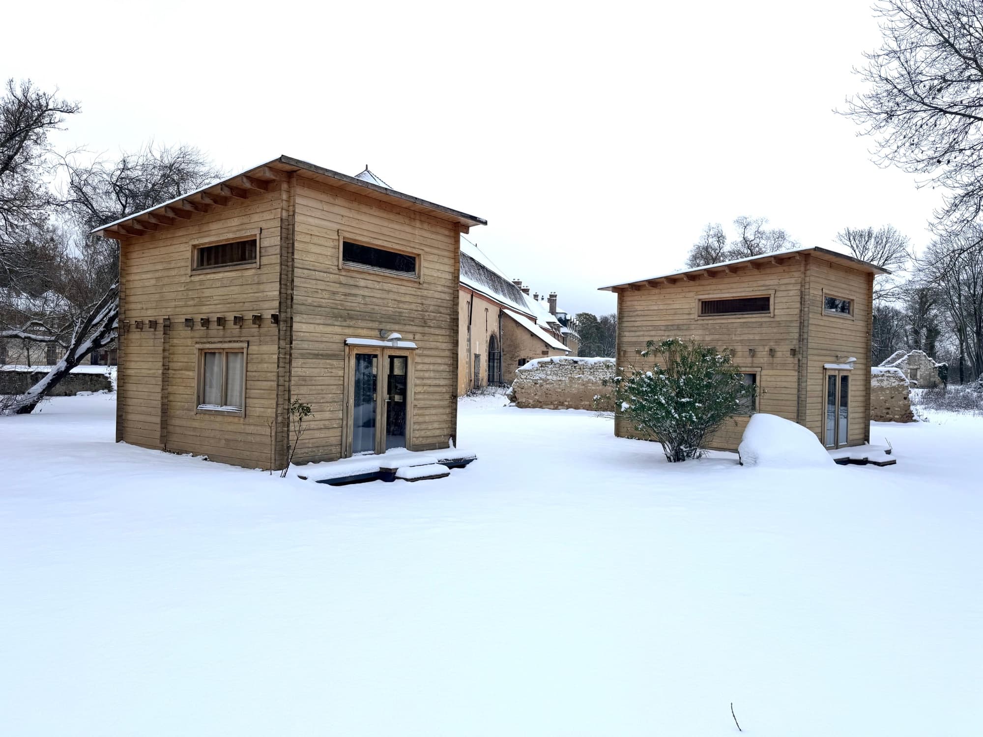 Lodges en bois sous la neige dans le parc du château de Motteux en hiver