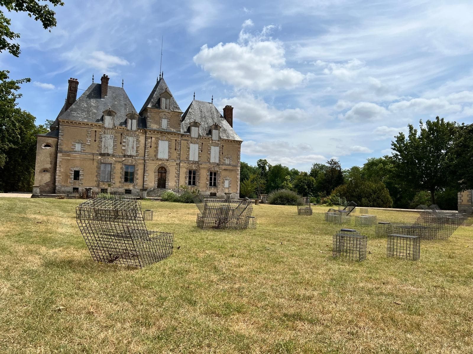 Façade du château de Motteux vue depuis le parc, mobilier de jardin design sur la pelouse