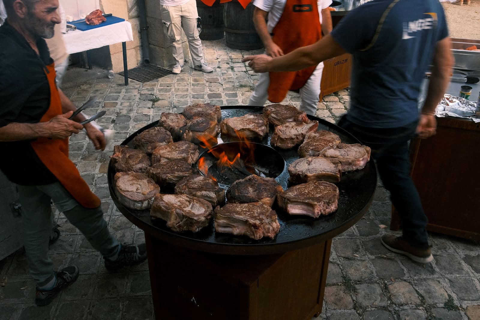 Grillades préparées devant les convives sur le grand braséro dressé dans la cour du château de Motteux