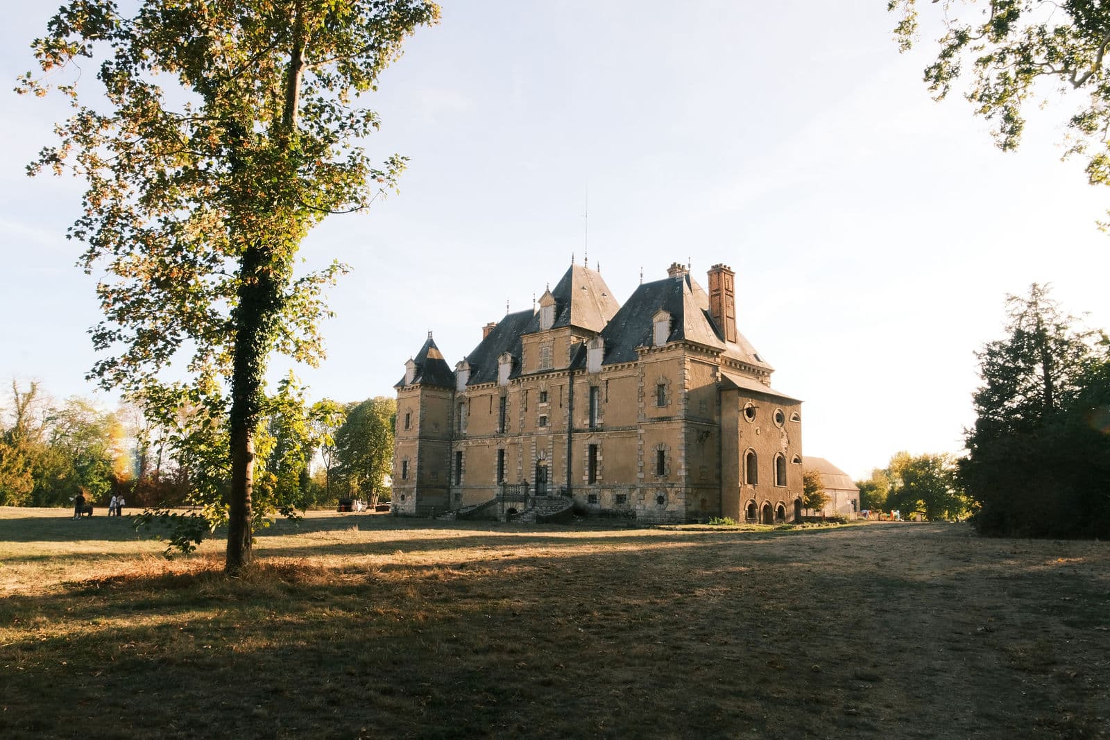 Le château de Motteux depuis la grande pelouse du parc, sous la lumière dorée d’un après-midi d’automne