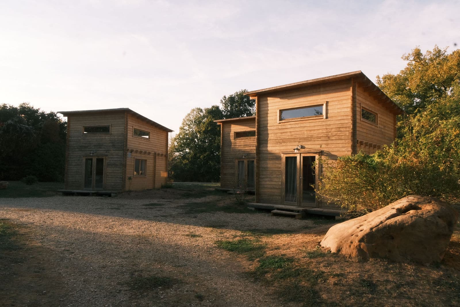 Deux chalets en bois du domaine de Motteux dans la lumière dorée de fin de journée