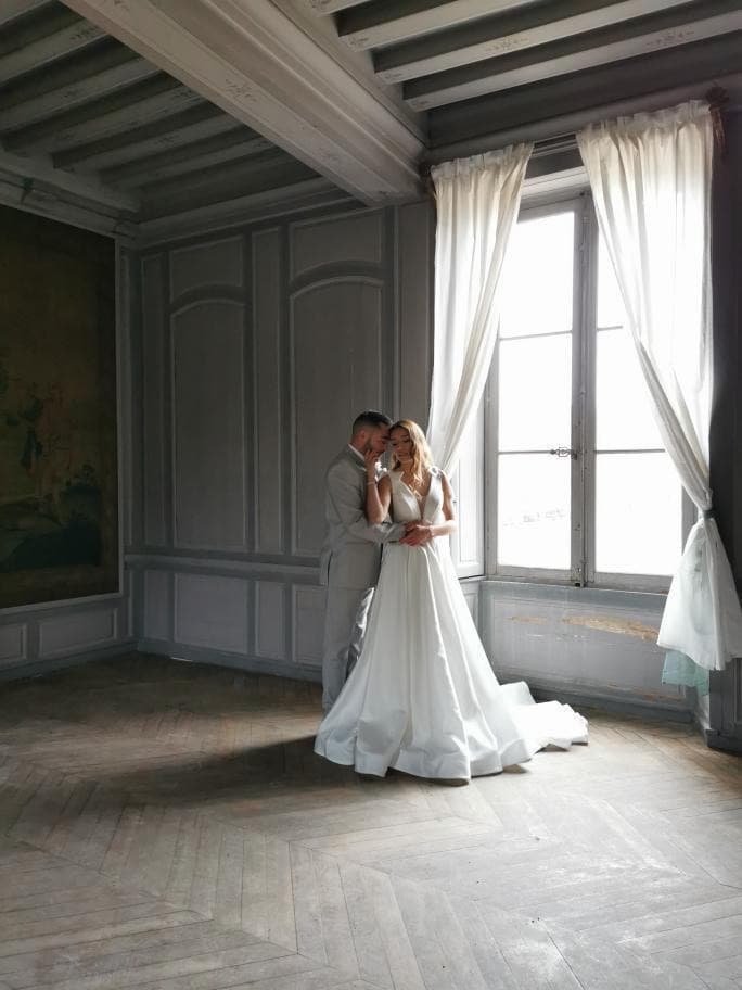 Couple de mariés dans un salon aux boiseries grises et parquet ancien du château de Motteux