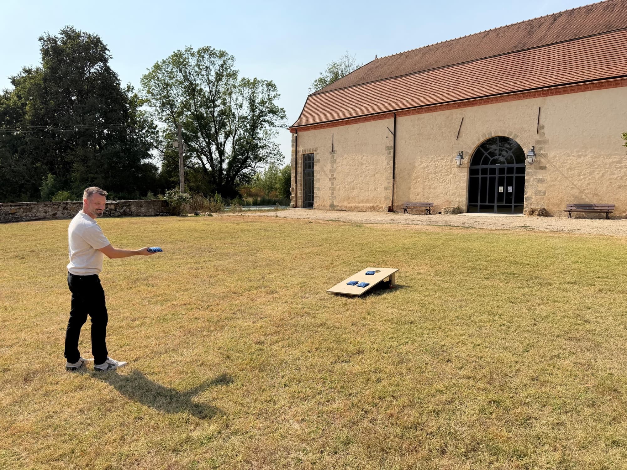 Jeu de plein air sur la pelouse devant la grange restaurée du château de Motteux