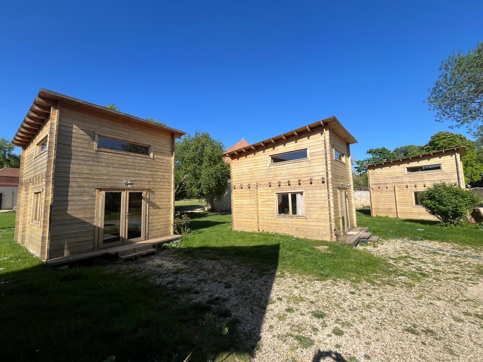 Lodges en bois dans le parc du château de Motteux sous le soleil de printemps