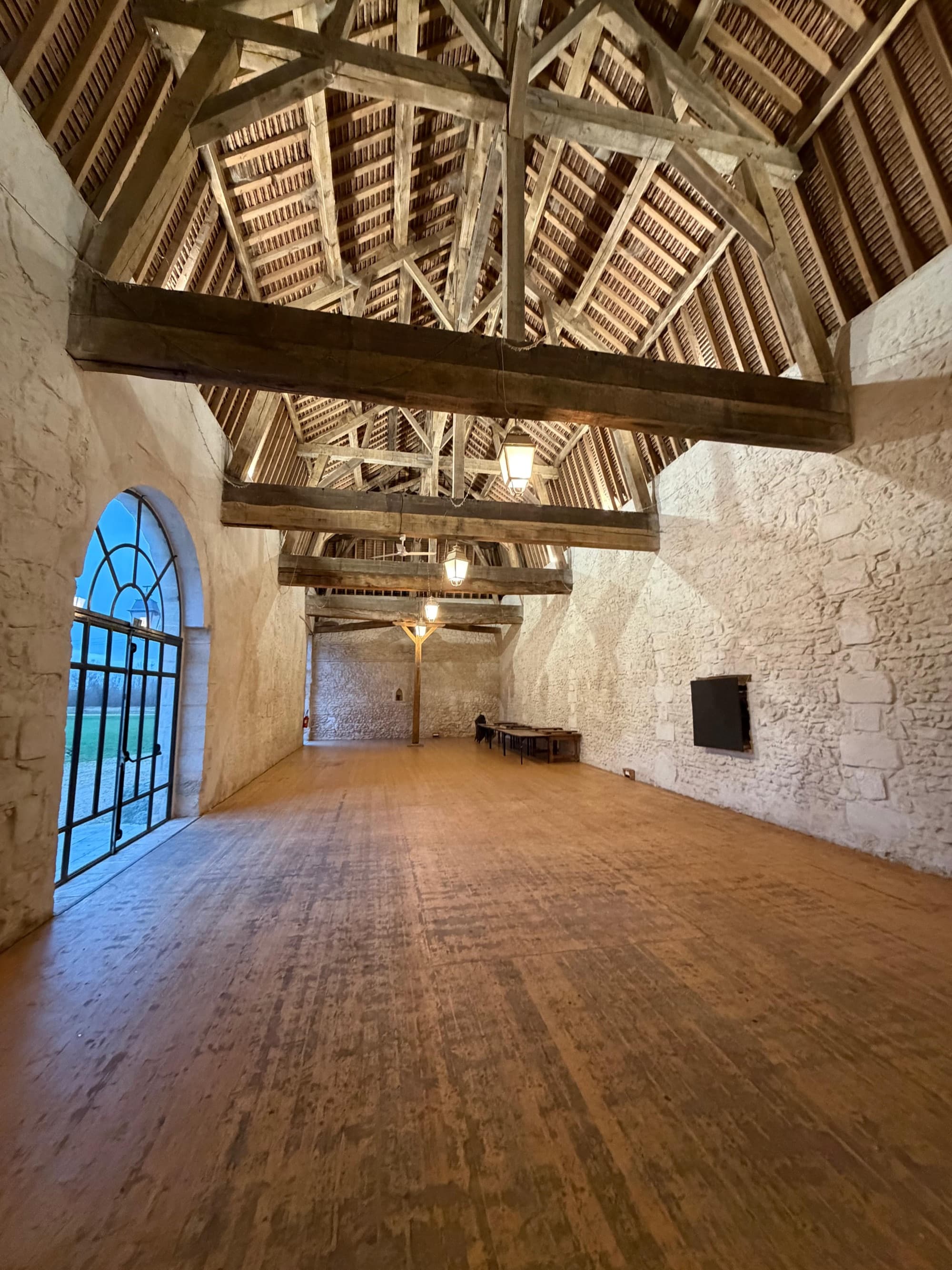 Grange Henri II du château de Motteux : charpente apparente et murs en pierre pour les cérémonies