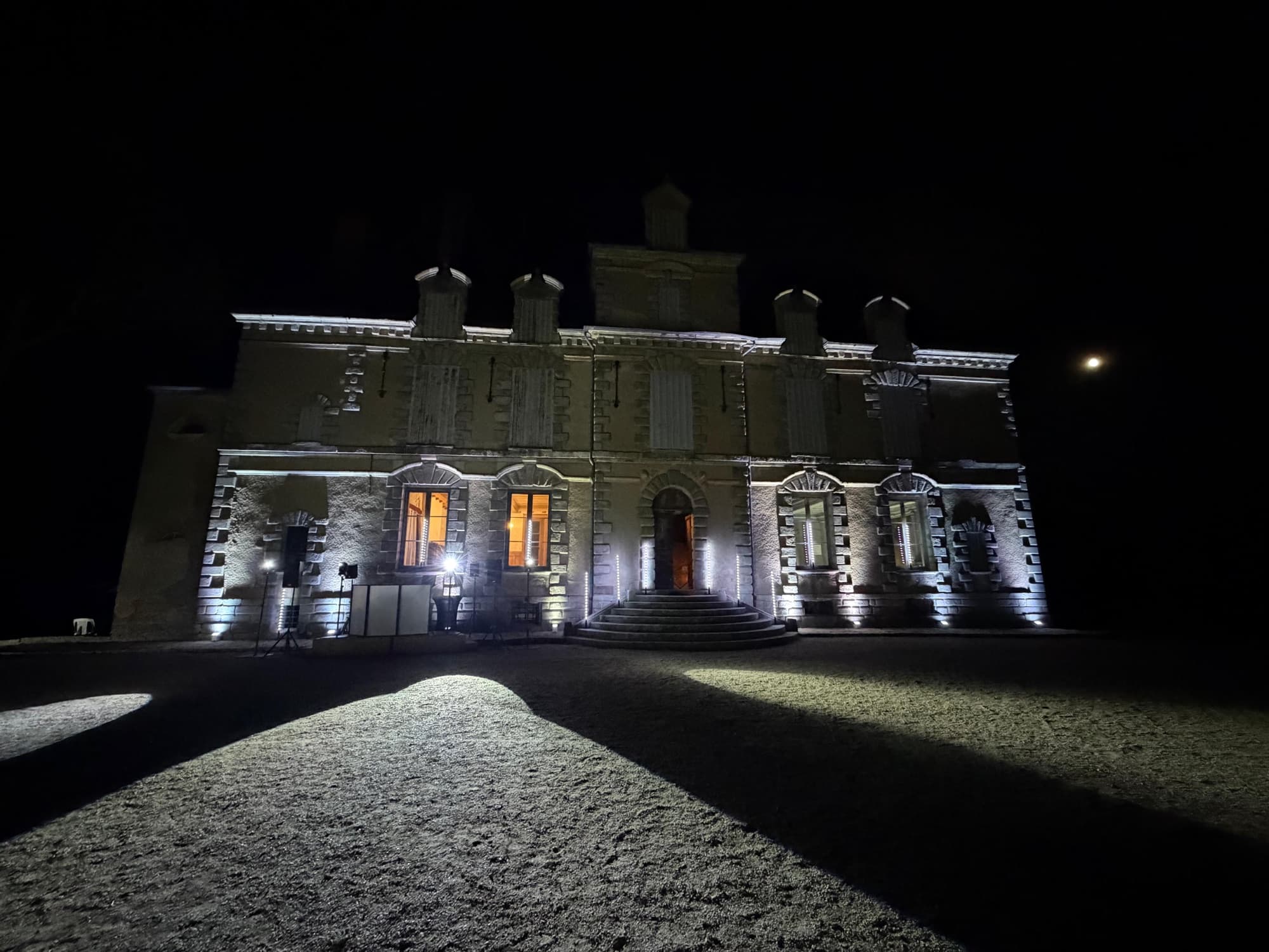 Façade du château de Motteux illuminée de nuit lors d’une réception avec mise en lumière blanche