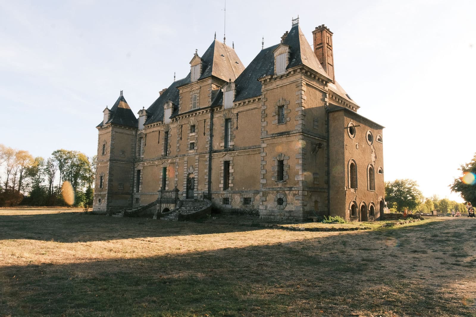 Château de Motteux vu de trois quarts en automne, tourelles, échauguette et façade de pierre dorée